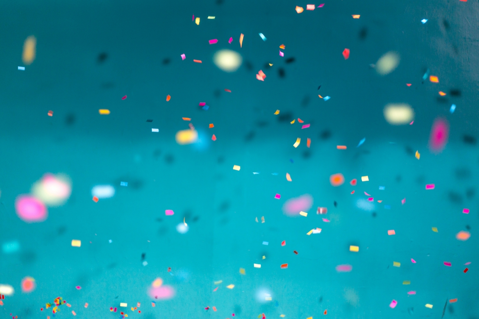 An decorative image of confetti against a light blue background